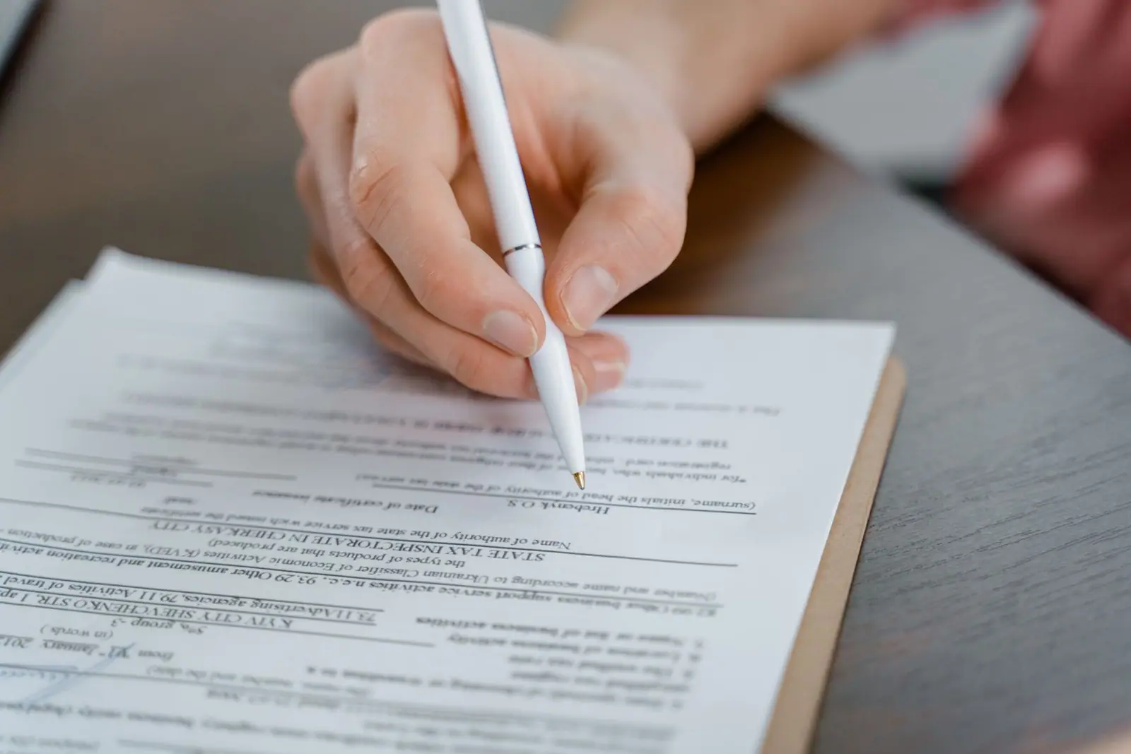 A hand holding a pen over a printed document